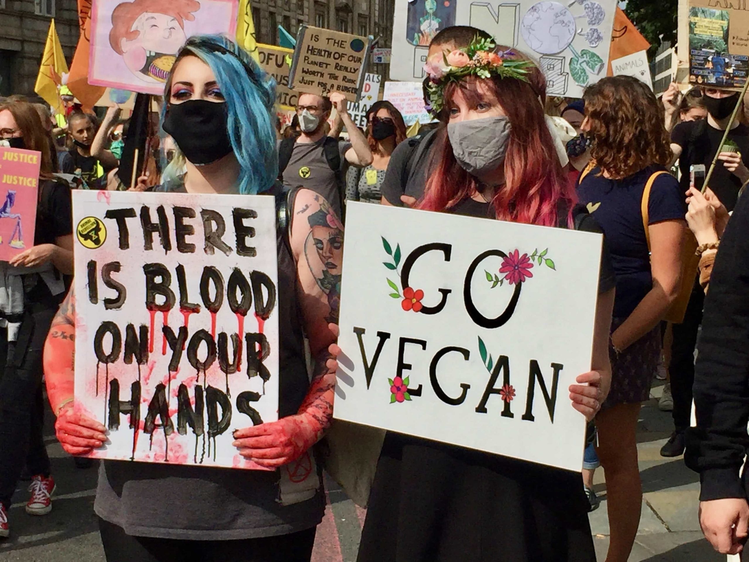 Girls holding vegan banners at the Animal Rebellion march to Parliament Square in London